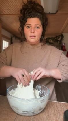 a woman is mixing something in a bowl