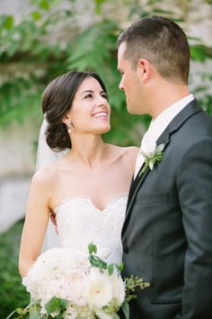 a bride and groom smile at each other