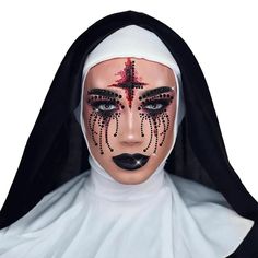 a woman with makeup on her face is wearing a nun's headdress