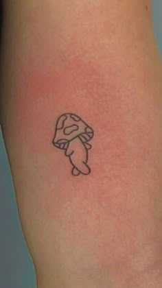 a small tattoo on the leg of a person with a mushroom on it's arm