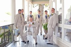 a group of men in suits standing next to each other on a porch with chairs