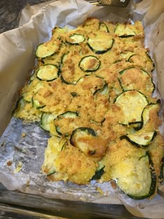 an uncooked casserole dish with zucchini and cheese on it