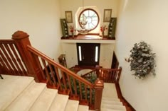 the stairs are made of wood and have white carpeting on them, along with a circular window