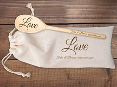 a wooden spoon sitting on top of a white bag with the word love written on it