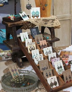 an assortment of earrings and necklaces are on display at a flea market in the city