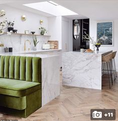 a green couch sitting in the middle of a living room next to a counter top