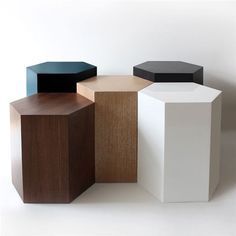 four different colored boxes sitting next to each other on a white surface with one black box in the middle