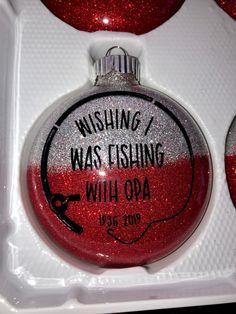 a red and white ornament in a box with writing on the bottom that says wishing was fishing with oa