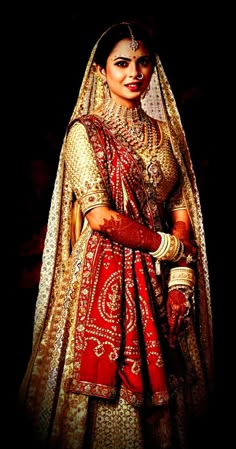 a woman in a red and gold bridal gown with her hands on her hips