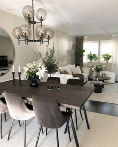 a dining room table with chairs and a mirror on the wall in front of it