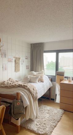 a bed room with a neatly made bed next to a window and a desk in front of it