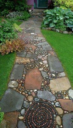 a walkway made out of rocks and stones in front of a purple house with green doors