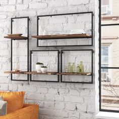 a living room with brick walls and shelves on the wall, along with an orange couch