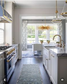 a kitchen with white cabinets and gold accents