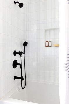 a white bath tub sitting next to a shower head