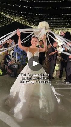 a woman in a wedding dress is dancing with streamers around her head and arms