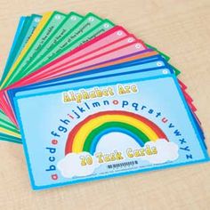 several children's books are stacked on top of each other with rainbows in the background