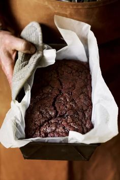 a close up of a person holding a piece of food in a paper bag with napkins