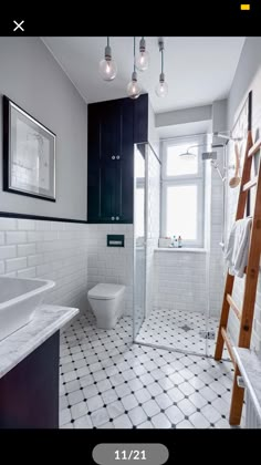 a bathroom with white and black tile flooring next to a ladder in the shower