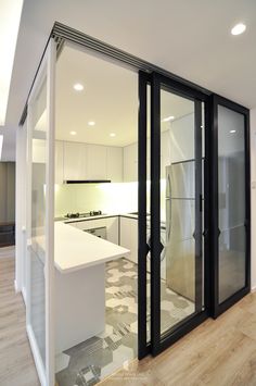 an empty kitchen with glass doors and white counter tops, is seen from the outside