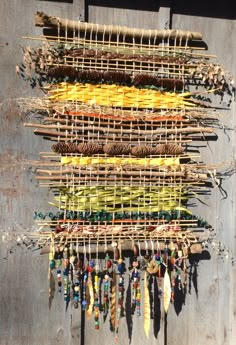 a wall hanging made out of sticks and beads