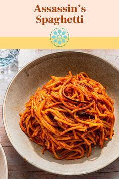 a bowl filled with spaghetti sitting on top of a wooden table