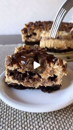 a piece of cake on a white plate with a fork in it and someone cutting into the cake