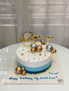 a white and blue cake with gold decorations