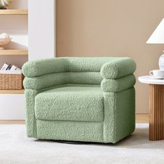 a green chair sitting in a living room next to a lamp