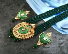 This is a stunning hand painted necklace perfect for high end Jewelry Collector, a keeper in Traditional Vintage Indian/Pakistani Bridal jewelry and a Luxury Gift for your Daughter, Sister or Wife on Wedding or Anniversary. Perfect for any type of occasions, weddings And celebrations and a beautiful & memorable gift for weddings and special occasions. -Item Code:- M455 -Rajwada Necklace Set with Earrings. -Designer multi layered Green beaded necklace with hand painted pendant. -Gold Plated Set with kundan which shine like precious stones. -Metal: Gold plated brass -Earrings are 65mm long & 32mm wide approx -Push Back Earrings -Necklace length with pendant 12" approx excluding adjustable dori/cord -Quantity:- One Necklace Set Please see more different designs here:- https://www.etsy.com/in- Traditional Hand Painted Round Beads Jewelry, Green Bollywood Necklaces With Peacock Design, Green Bollywood Necklace With Peacock Design, Green Necklace With Peacock Design For Diwali, Green Peacock Design Necklace For Diwali, Green Kundan Beaded Necklace Gift, Festive Green Bridal Necklace With Peacock Design, Green Bridal Necklace With Round Beads As A Gift, Festive Green Peacock Design Bridal Necklace