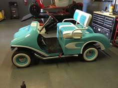 a blue and white toy car in a garage with tools on the wall behind it