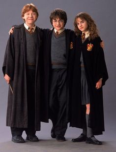 three children dressed in harry potter costumes posing for a photo with their arms around each other