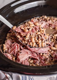 a slow cooker filled with beans and ham