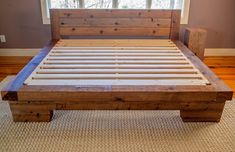 a bed frame made out of wood with white slats on the headboard and foot board