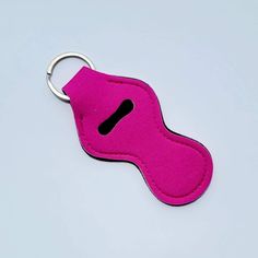 a pink keychain with a black letter on the front and bottom part of it