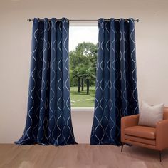 an orange chair sitting in front of a window with blue drapes on top of it