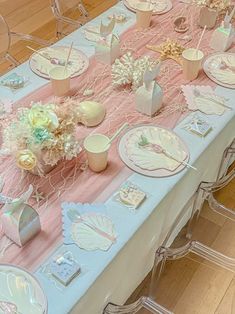 a table set up with plates, cups and vases