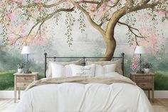 a bedroom with a large tree mural on the wall and bed in front of it