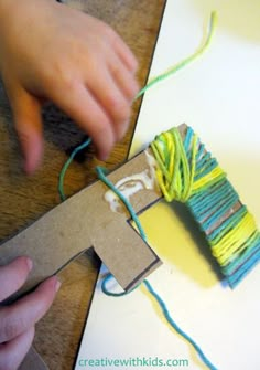 someone is making a craft with yarn and scissors