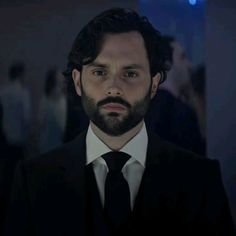 a man in a suit and tie looking at the camera with an intense look on his face