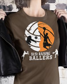 a woman wearing a t - shirt that says busy raising ballers