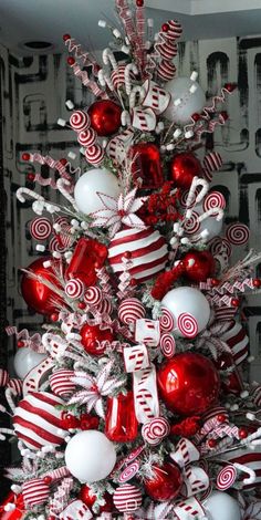 a red and white christmas tree with candy canes on it's branches,