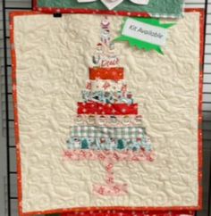 a quilted christmas tree hanging on the wall