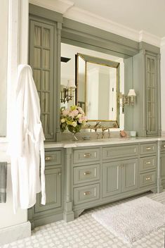 a bathroom with gray cabinets and white towels