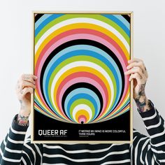 a person holding up a poster with an image of a colorful spiral in the middle