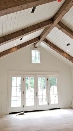 an empty room with wooden beams and white doors