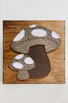 A large and small mushroom made in string art using dark and light brown tone string on a piece of stained wood. Mail And Thread Art, Nail And Yarn Art Designs, Wooden String Art, Mushroom String Art, Nail String Art Patterns, String Crafts Ideas, Thread Art On Wood, Nail And String Art Patterns, Nail String Art Template