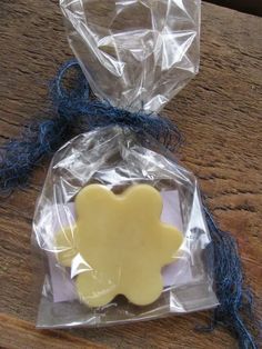 a cookie shaped like a bear in a bag on top of a wooden table with blue string