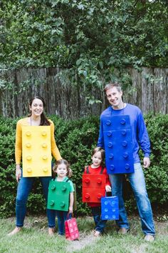 a family dressed up in legos standing next to each other with their child's luggage