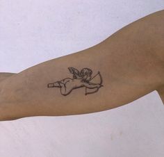 a small tattoo on the arm of a man with an angel flying over it's head